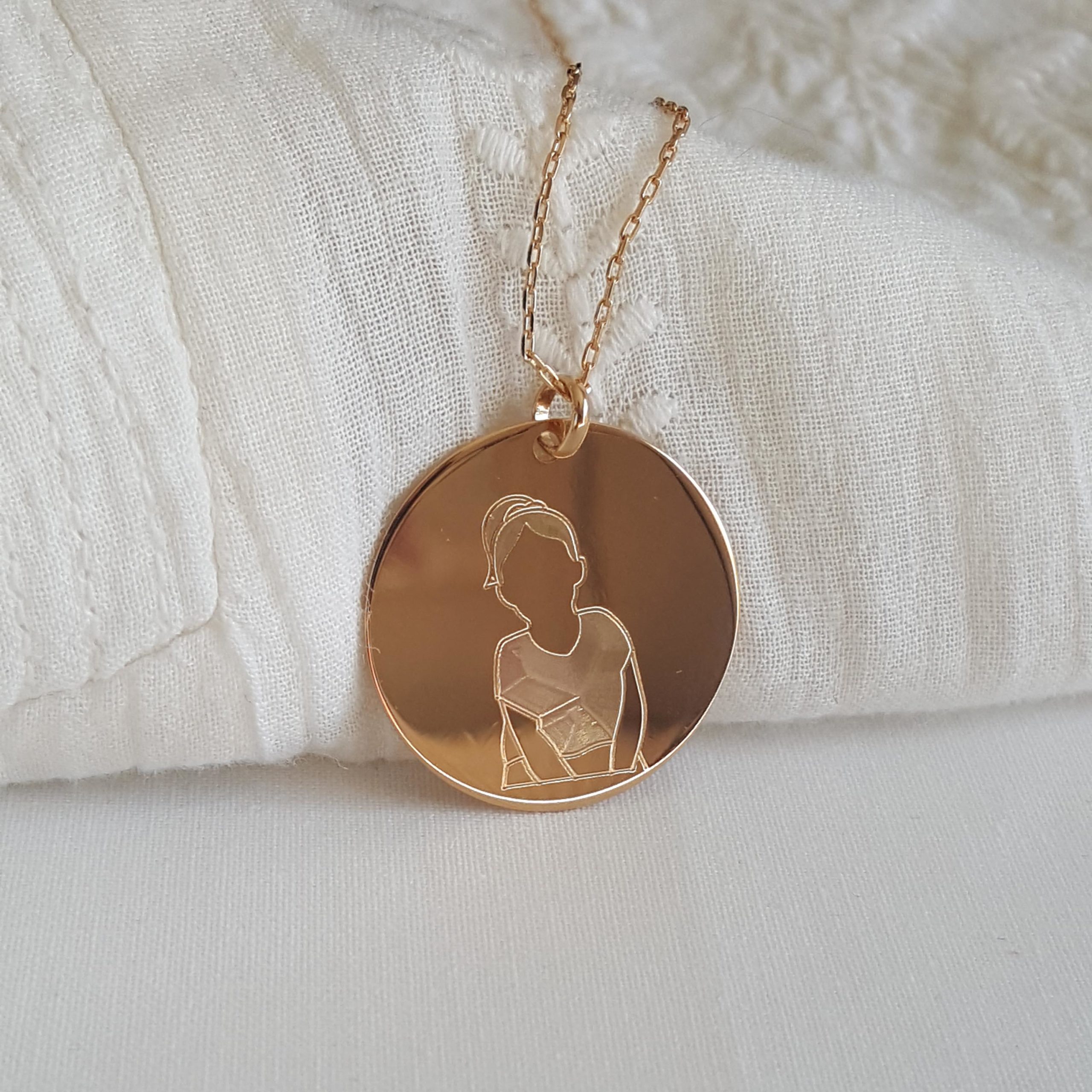 Médaille personnalisé avec une illustration portrait enfant gravé sur le bijou en plaqué or
